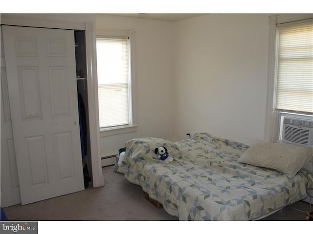 carpeted bedroom with a baseboard radiator and cooling unit