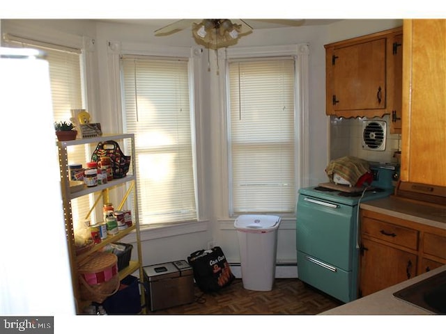 kitchen with ceiling fan, a baseboard radiator, and dark parquet flooring