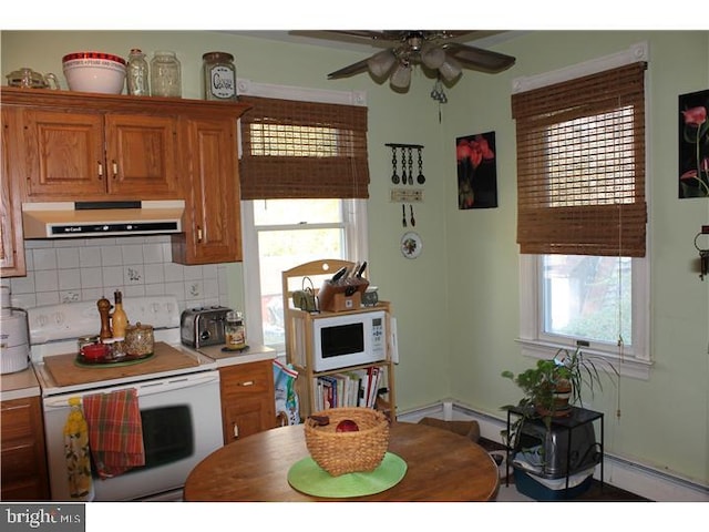 kitchen featuring backsplash, ceiling fan, plenty of natural light, and white appliances