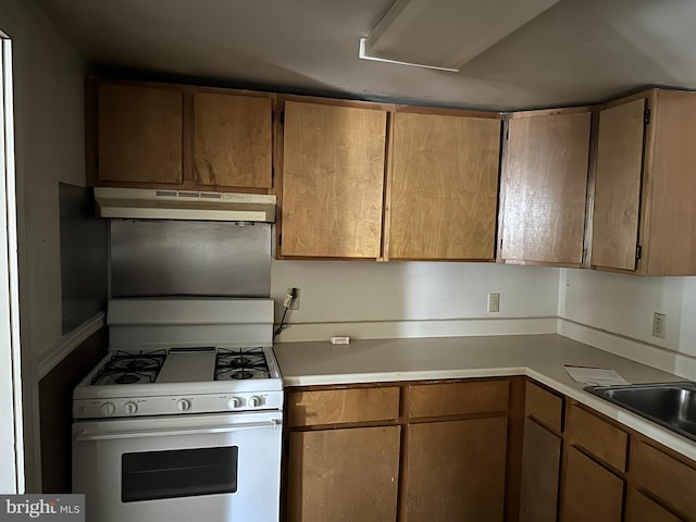 kitchen featuring white gas range and sink