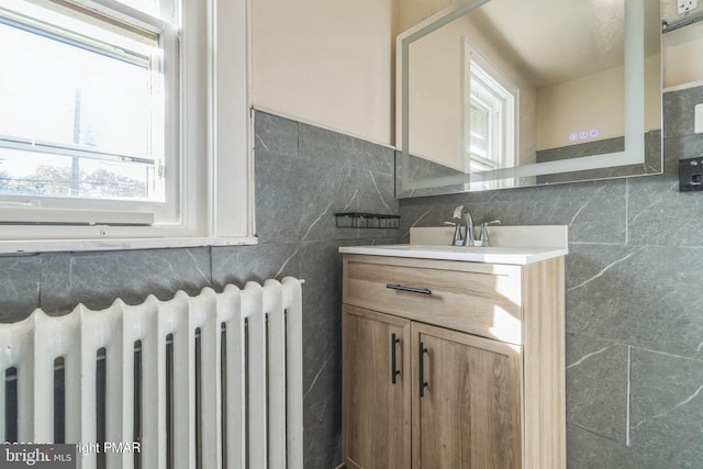 bathroom with vanity, tile walls, and radiator heating unit