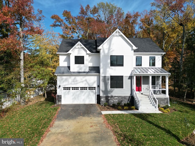 view of front of house featuring covered porch, a front yard, and a garage