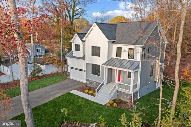 view of front of house with a porch, a garage, and a front lawn