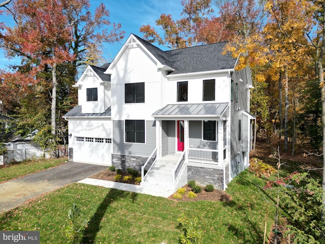 modern inspired farmhouse featuring a front yard, a porch, and a garage