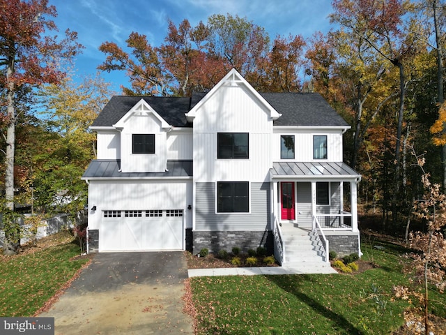 modern farmhouse style home with covered porch, a garage, and a front yard