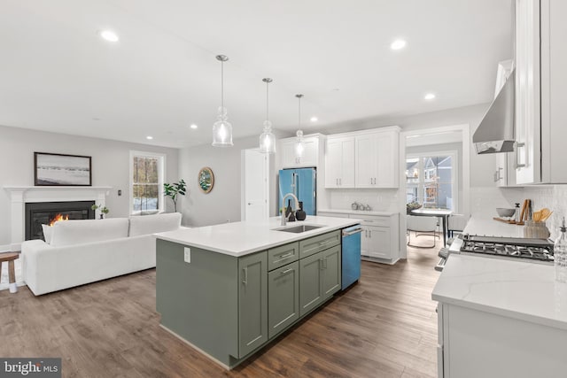 kitchen with hanging light fixtures, a wealth of natural light, dark wood-type flooring, and wall chimney range hood