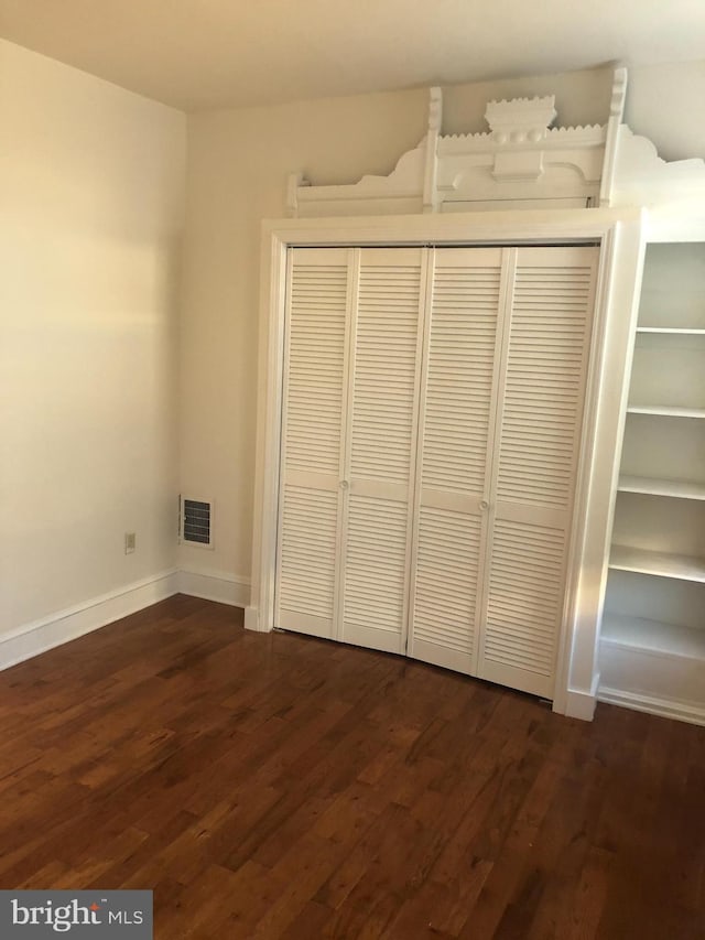 unfurnished bedroom featuring dark hardwood / wood-style flooring