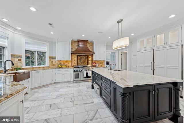 kitchen featuring white cabinetry, sink, double oven range, custom range hood, and decorative light fixtures