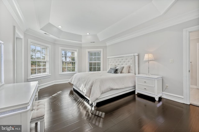 bedroom featuring ornamental molding, dark wood-type flooring, and a tray ceiling