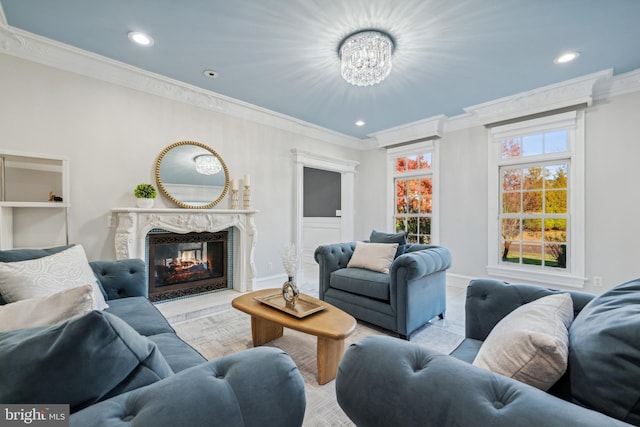 living room featuring a premium fireplace, a notable chandelier, and ornamental molding