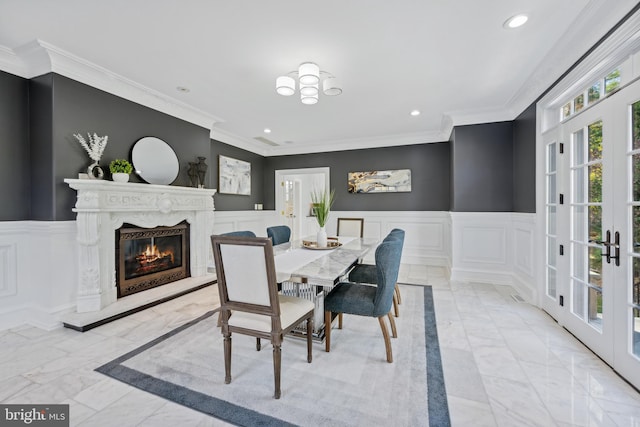 dining room with ornamental molding, french doors, and a premium fireplace