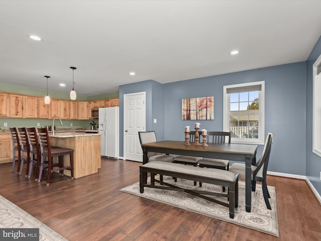 dining room with dark hardwood / wood-style floors and sink