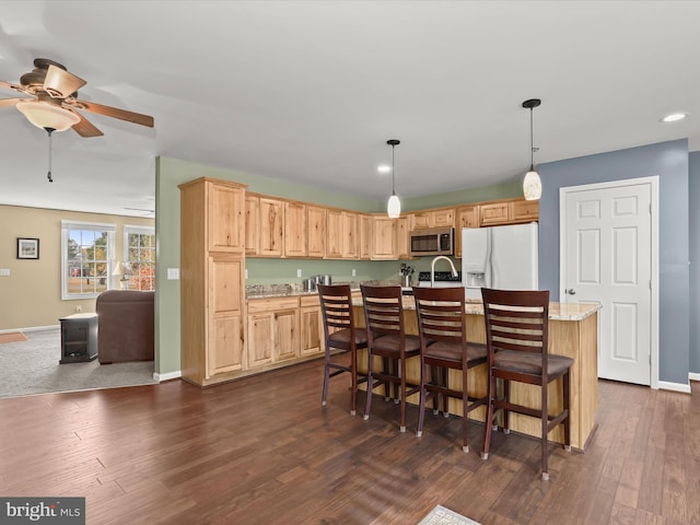 kitchen with light brown cabinets, a kitchen island with sink, white refrigerator with ice dispenser, and dark hardwood / wood-style floors