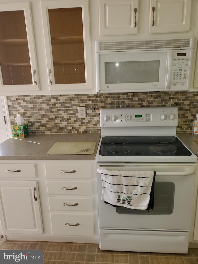 kitchen with white cabinets, backsplash, and white appliances