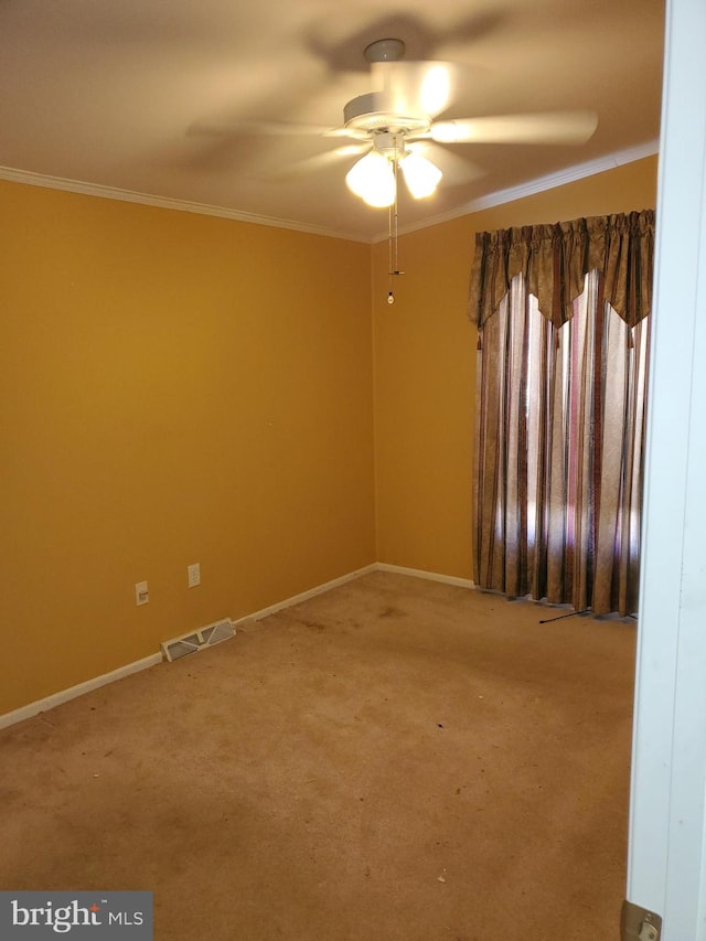 empty room featuring ceiling fan, light carpet, and ornamental molding