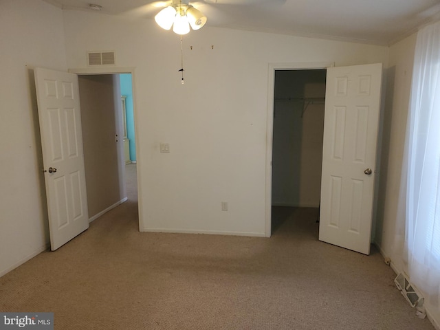 unfurnished bedroom with a closet, ceiling fan, lofted ceiling, and light colored carpet