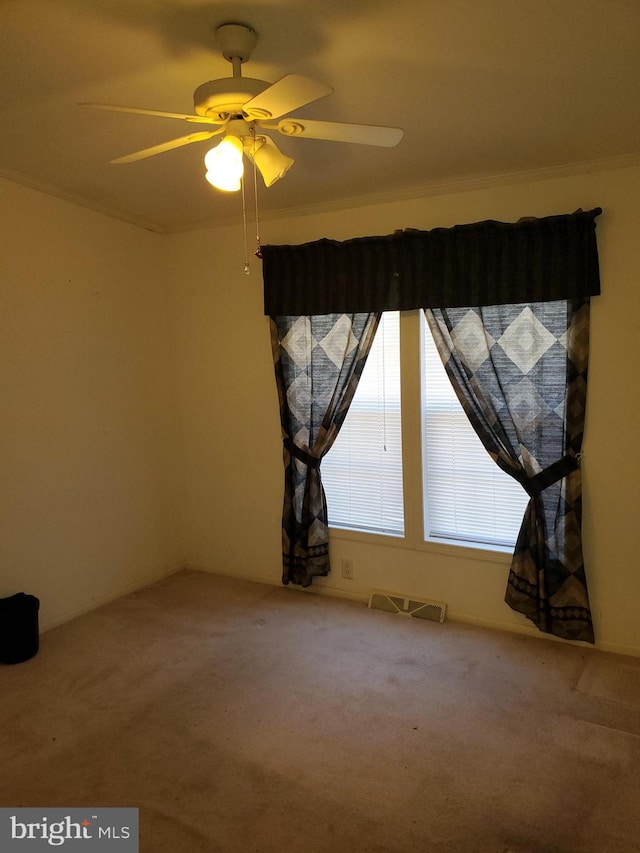 carpeted empty room with ornamental molding and ceiling fan