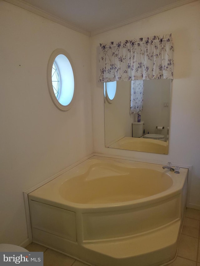 bathroom with crown molding, a tub, toilet, and tile patterned flooring