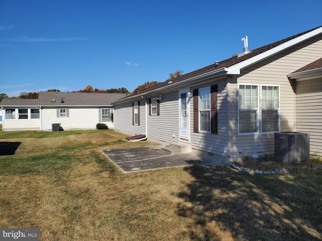 back of property with cooling unit and a lawn