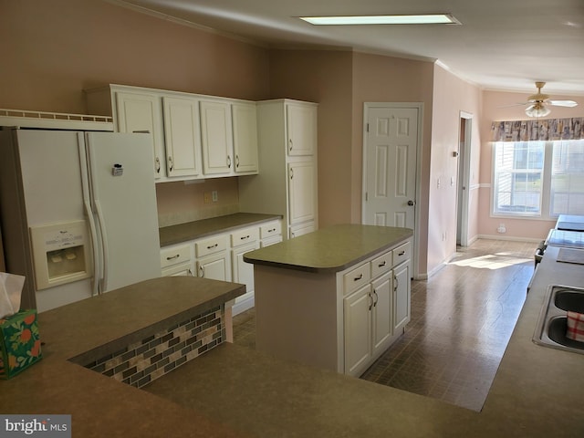 kitchen with a kitchen island, white refrigerator with ice dispenser, white cabinetry, ceiling fan, and dark hardwood / wood-style floors