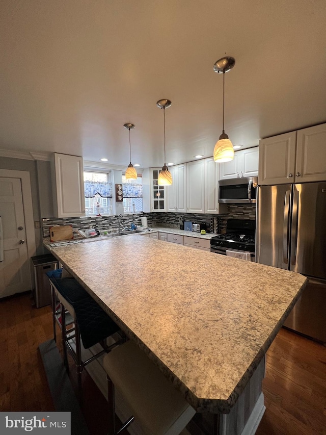 kitchen with dark hardwood / wood-style floors, white cabinetry, and appliances with stainless steel finishes