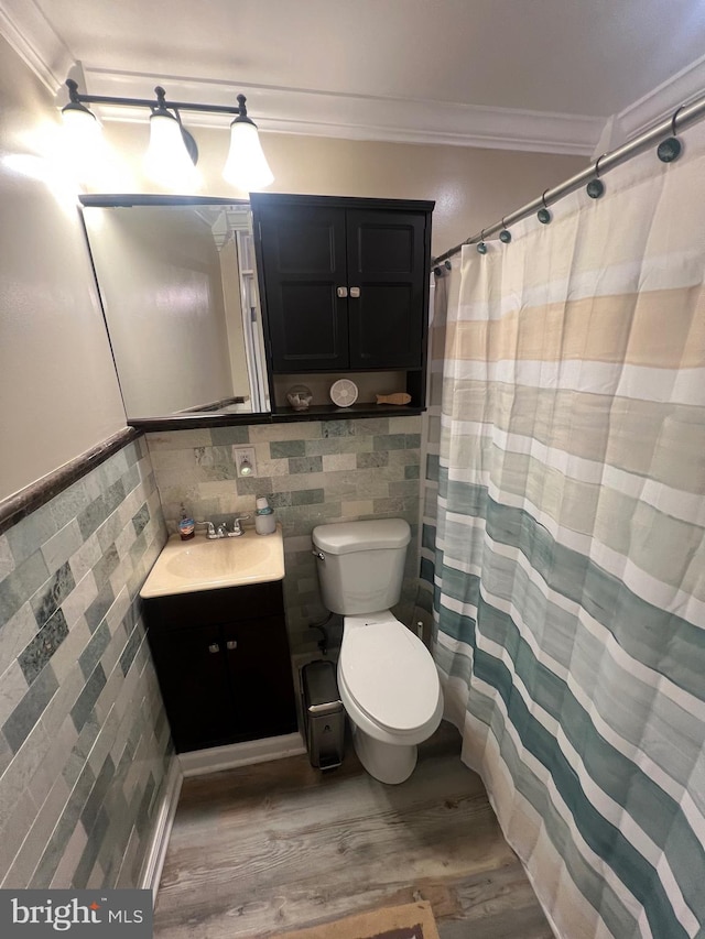 bathroom with crown molding, tile walls, and hardwood / wood-style flooring