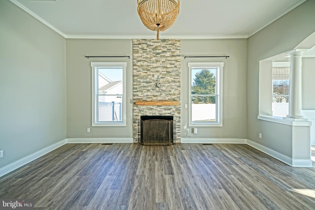 unfurnished living room featuring a fireplace, hardwood / wood-style flooring, decorative columns, and crown molding