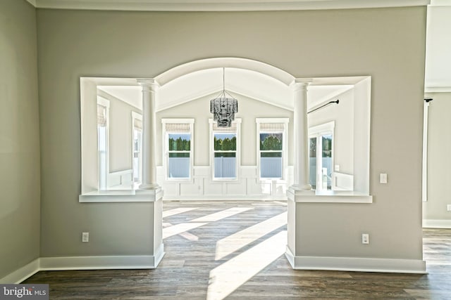 foyer with ornate columns, lofted ceiling, dark hardwood / wood-style floors, and an inviting chandelier