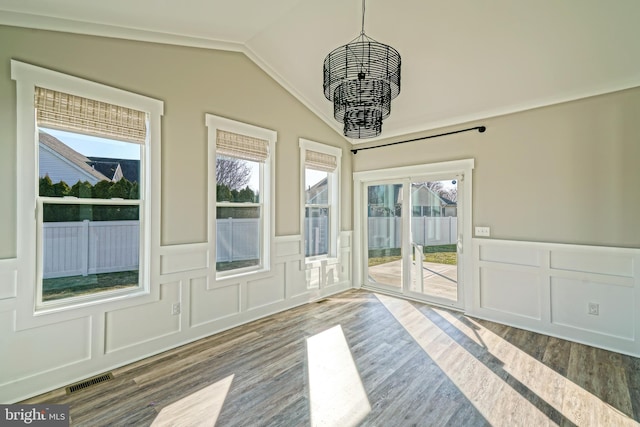 empty room featuring a chandelier, lofted ceiling, and hardwood / wood-style flooring