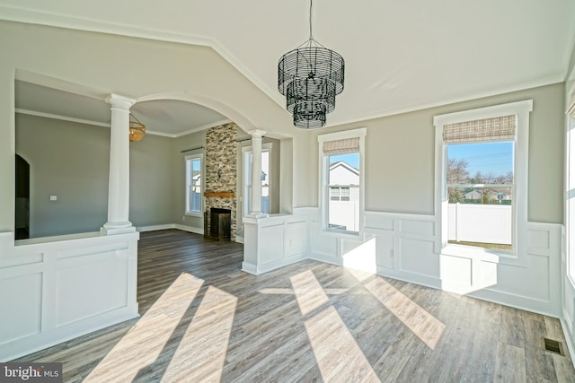 interior space with a wealth of natural light, a fireplace, crown molding, and hardwood / wood-style flooring