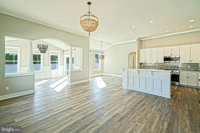 kitchen featuring ornate columns, white cabinets, stainless steel appliances, and decorative light fixtures