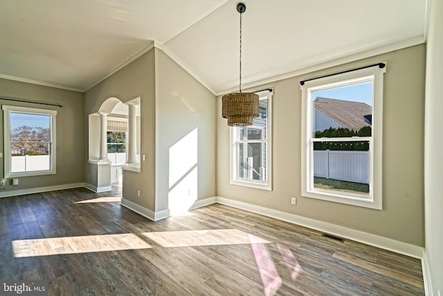 unfurnished dining area with lofted ceiling, decorative columns, hardwood / wood-style flooring, and ornamental molding