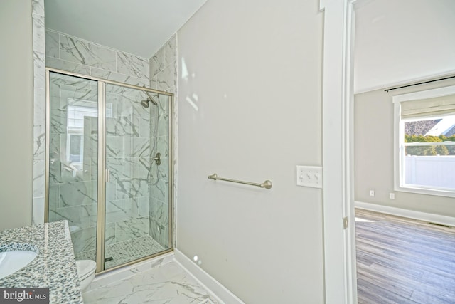 bathroom with hardwood / wood-style floors, vanity, toilet, and walk in shower