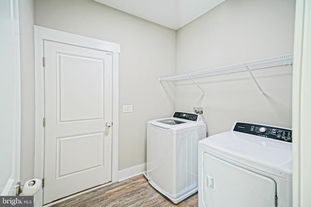 laundry area with wood-type flooring and washer and clothes dryer