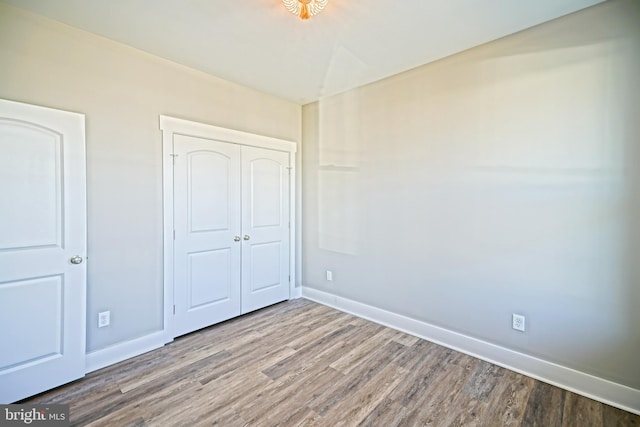 unfurnished bedroom featuring hardwood / wood-style flooring and a closet