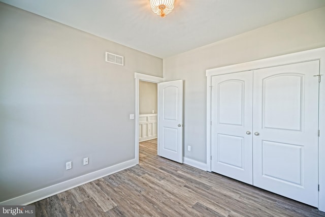 unfurnished bedroom with a closet and hardwood / wood-style flooring