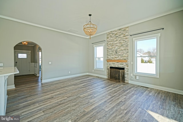 unfurnished living room featuring a fireplace, dark hardwood / wood-style flooring, plenty of natural light, and ornamental molding