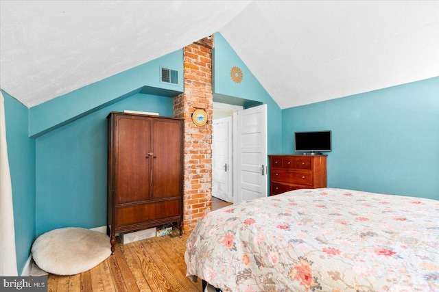 bedroom featuring hardwood / wood-style flooring and lofted ceiling