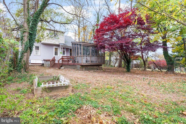 back of property featuring a sunroom and a wooden deck