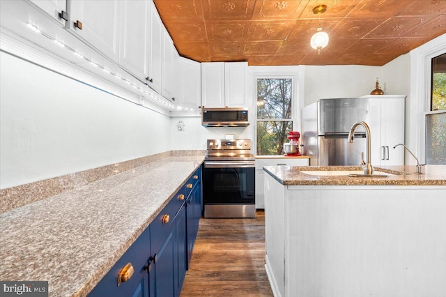 kitchen with white cabinetry, blue cabinets, dark wood-type flooring, and appliances with stainless steel finishes