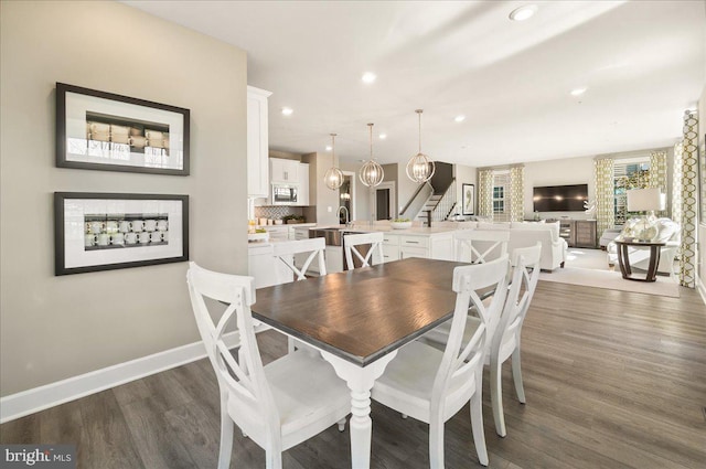 dining area featuring sink and dark wood-type flooring