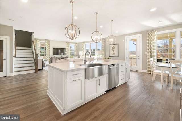 kitchen with a center island with sink, dishwasher, a healthy amount of sunlight, and white cabinetry