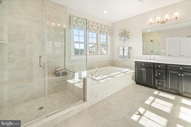 bathroom featuring tile patterned flooring, vanity, and shower with separate bathtub