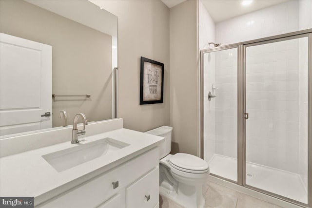 bathroom with tile patterned flooring, vanity, toilet, and walk in shower