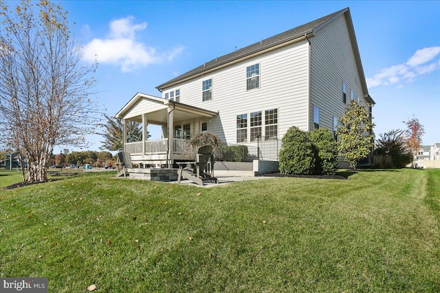 back of house featuring a lawn and a patio area