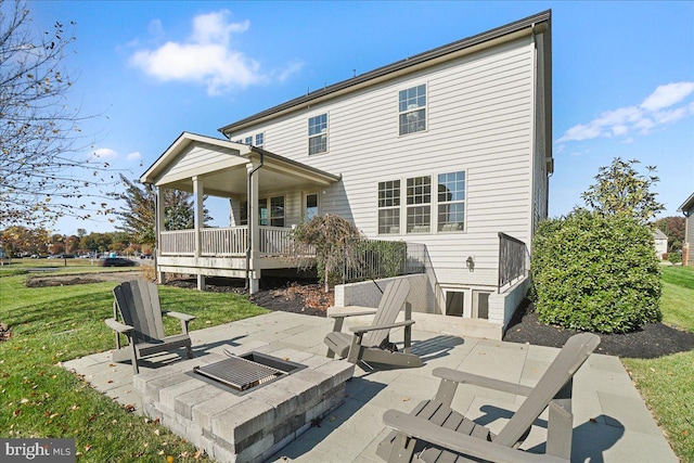 rear view of property with a patio area, a yard, and an outdoor fire pit