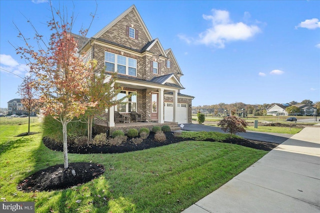 craftsman house with covered porch, a front yard, and a garage