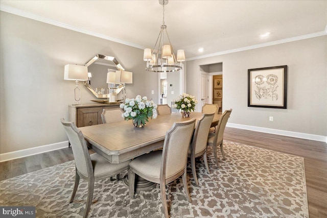 dining area featuring crown molding, dark wood-type flooring, and a chandelier