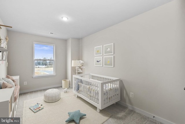 bedroom featuring a crib and carpet floors