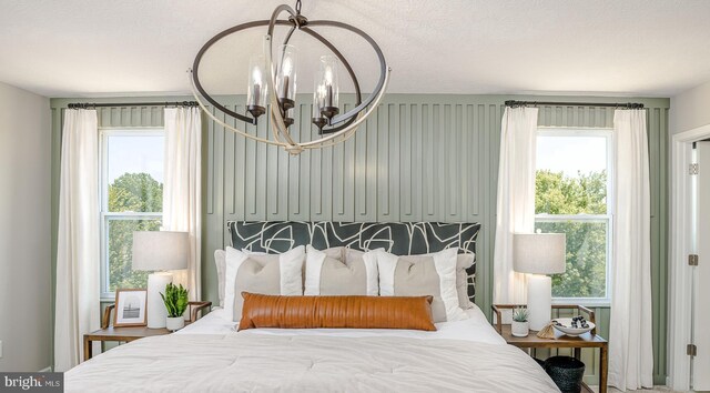 bedroom with a chandelier and multiple windows